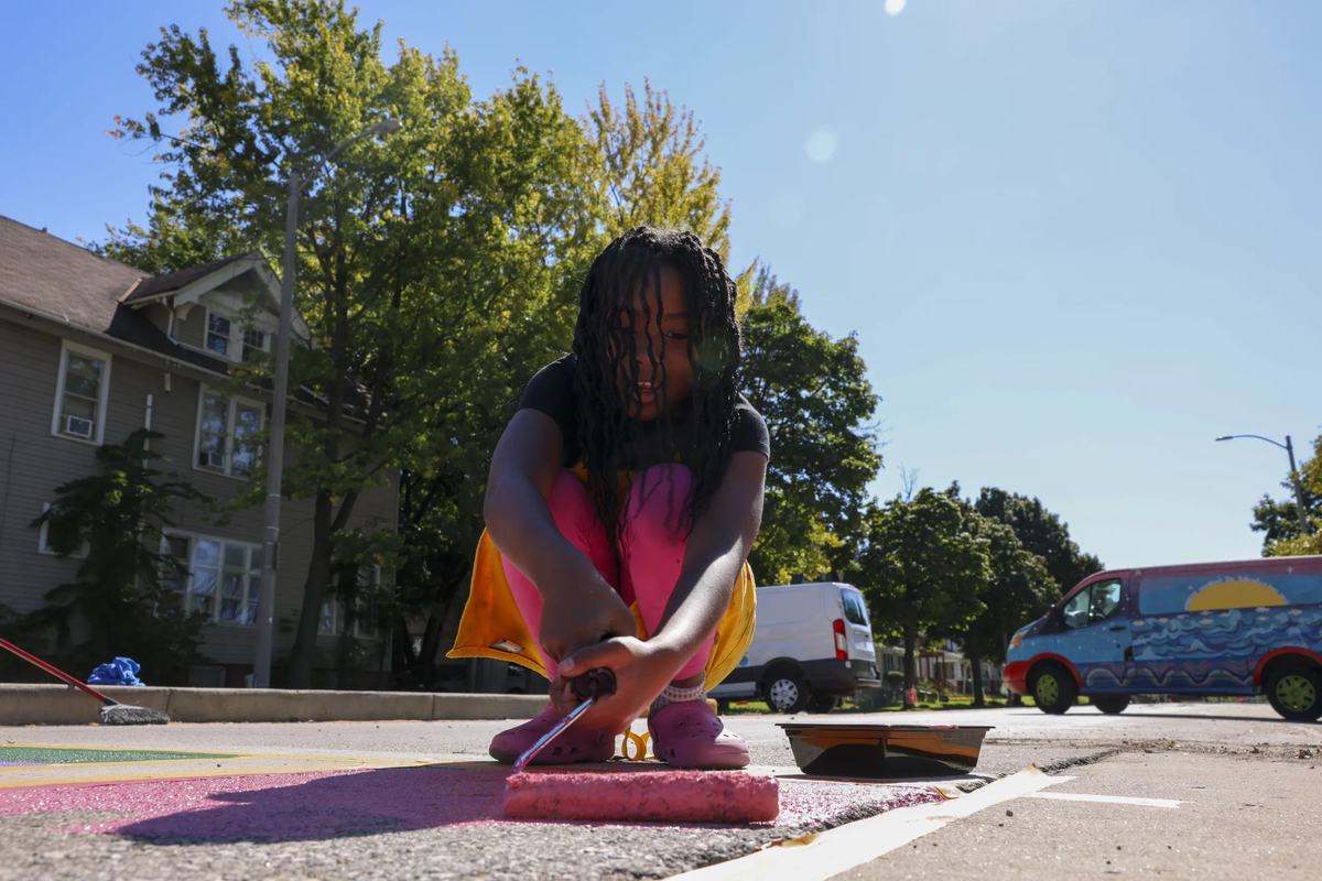 Journee Wilson, 8, paints a crosswalk mural.