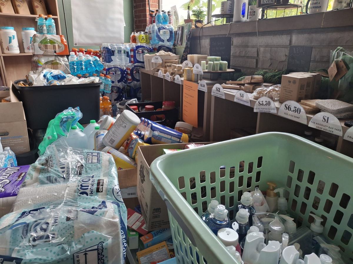 Boxes, baskets and shelves hold bottled water, sports drinks, paper goods, cleaning supplies, soap and other packaged items.