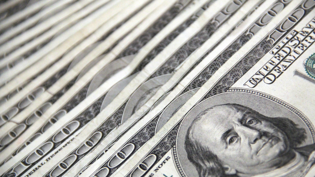 A stack of 100 dollar bills spread out.