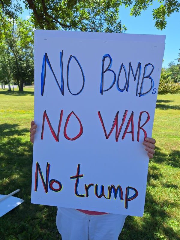 Sign reading No Bombs No War No Trump