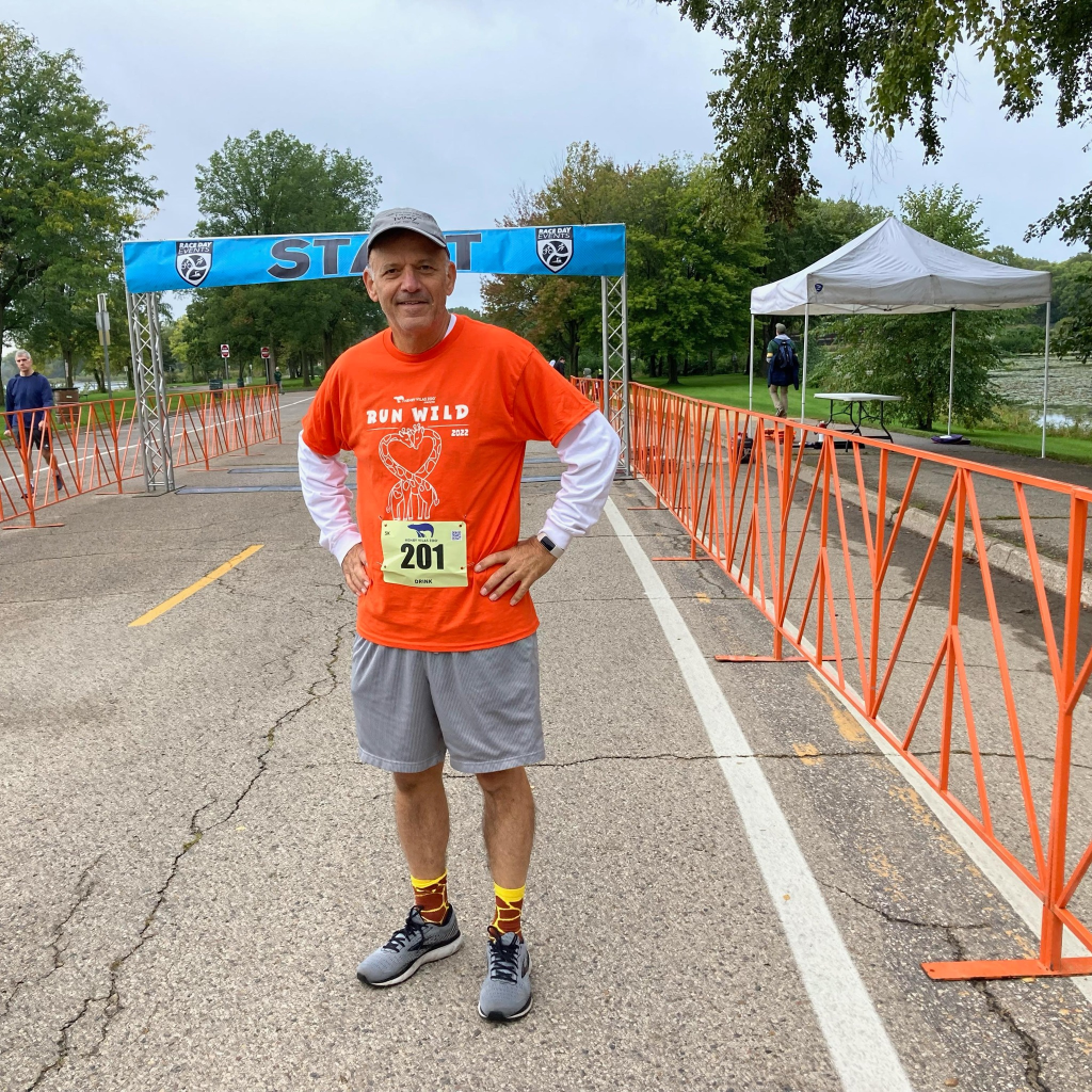 Photo of Gary Albrech in front of the start zone at a 5k