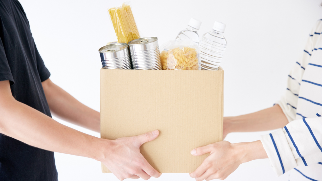 A box filled with cans, pasta and water to represent food share and SNAP benefits.